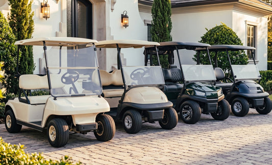 Four Club Car golf cart generations lined up on a brick driveway, from the older squared DS body to the modern sculpted Onward and Tempo bodies